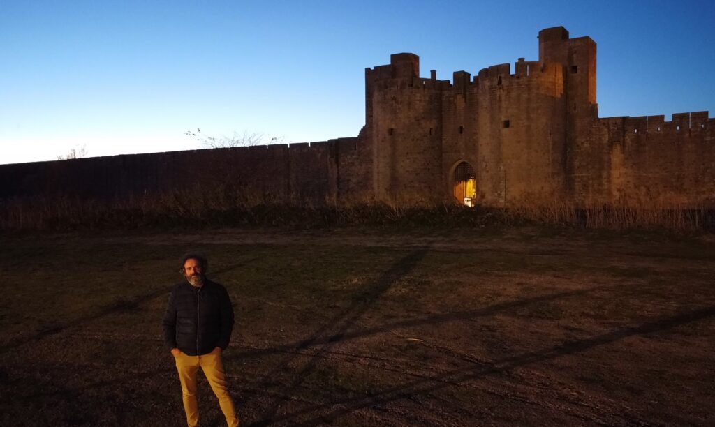Dimitri Moulins, fondateur de Voyages Authentiques, devant les remparts d'Aigues-Mortes au coucher de soleil